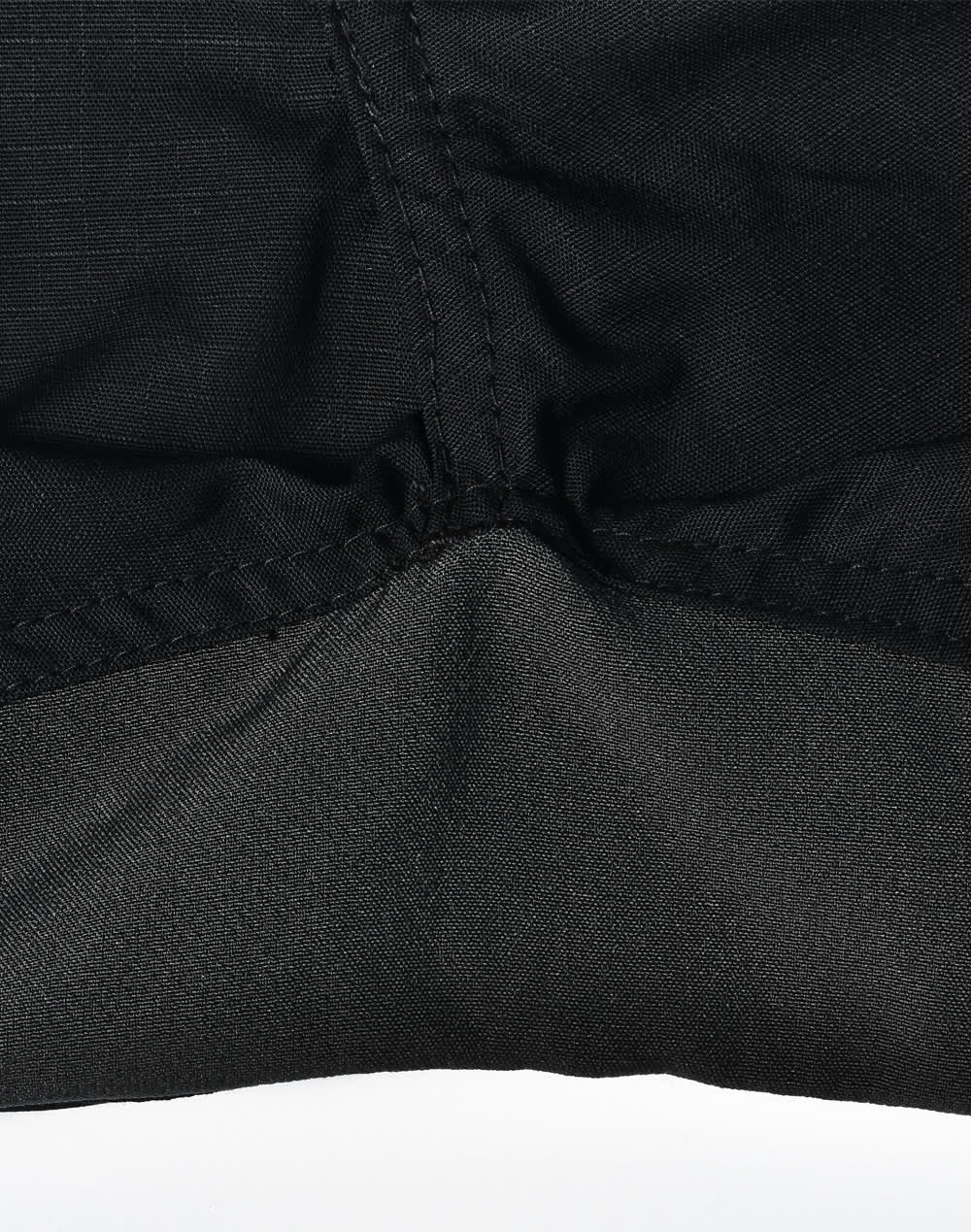 A close-up of black Rip-Stop Poly/Cotton Stretch Work Pants highlighting the fabric texture and stitching details.