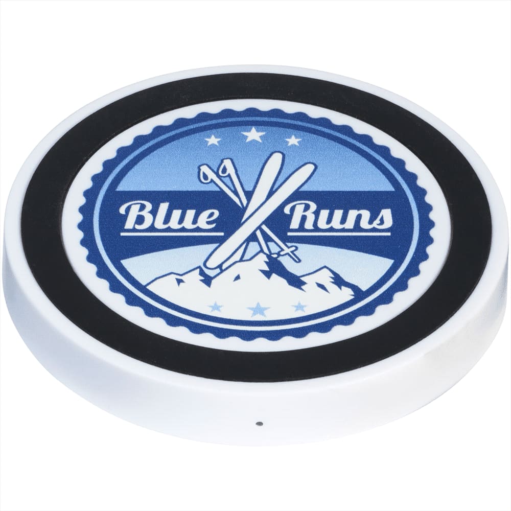 A wireless charging pad featuring a blue and white design with crossed skis and a mountain graphic, in white and solid black.