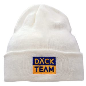 A cream acrylic beanie with a deep fit, featuring a logo in blue and gold.