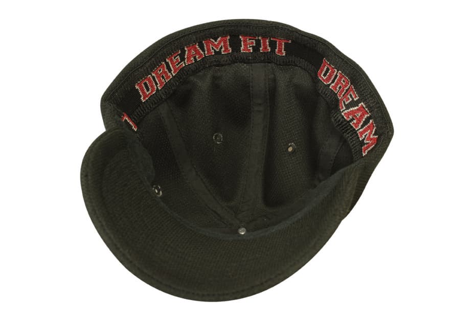 A black cap with a curved brim and an interior band featuring a logo, showcasing heavy cotton and spandex material.