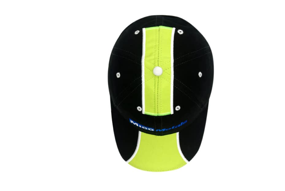 A black cap with fluorescent green fabric inserts on the crown and peak, featuring a logo.
