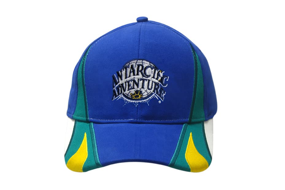 A blue cap featuring green and yellow accents with a logo on the front. It has peak inserts and embroidery details.