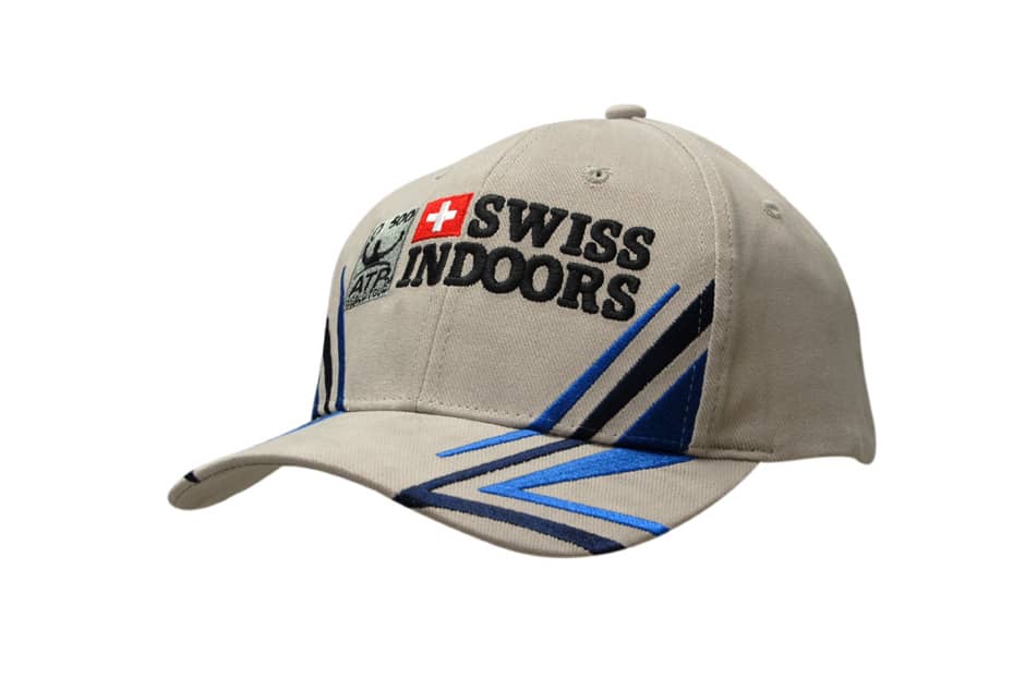 A beige cap featuring peak and crown strike embroidery in blue, with a logo on the front.
