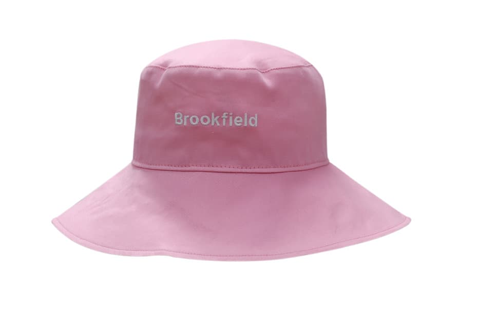 A pink cotton twill ladies hat with a wide brim and a logo on the front.