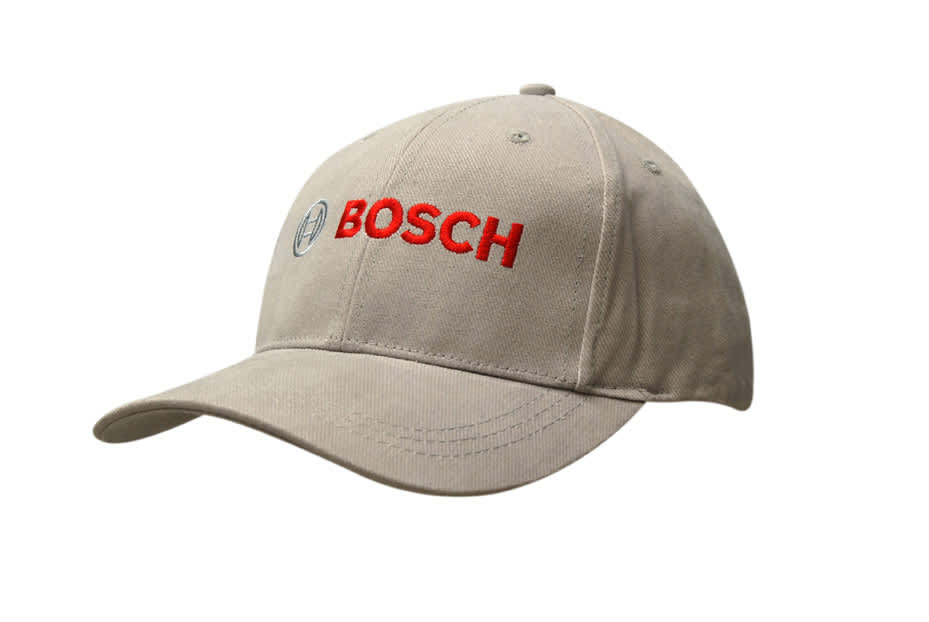 A beige cap with a contrasting peak, featuring a logo on the front and embroidered text in red.