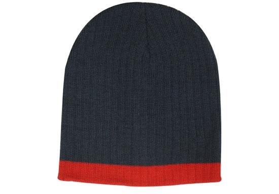 A two-tone cable knit beanie featuring a dark grey body and a bright red band at the bottom. It includes a logo.