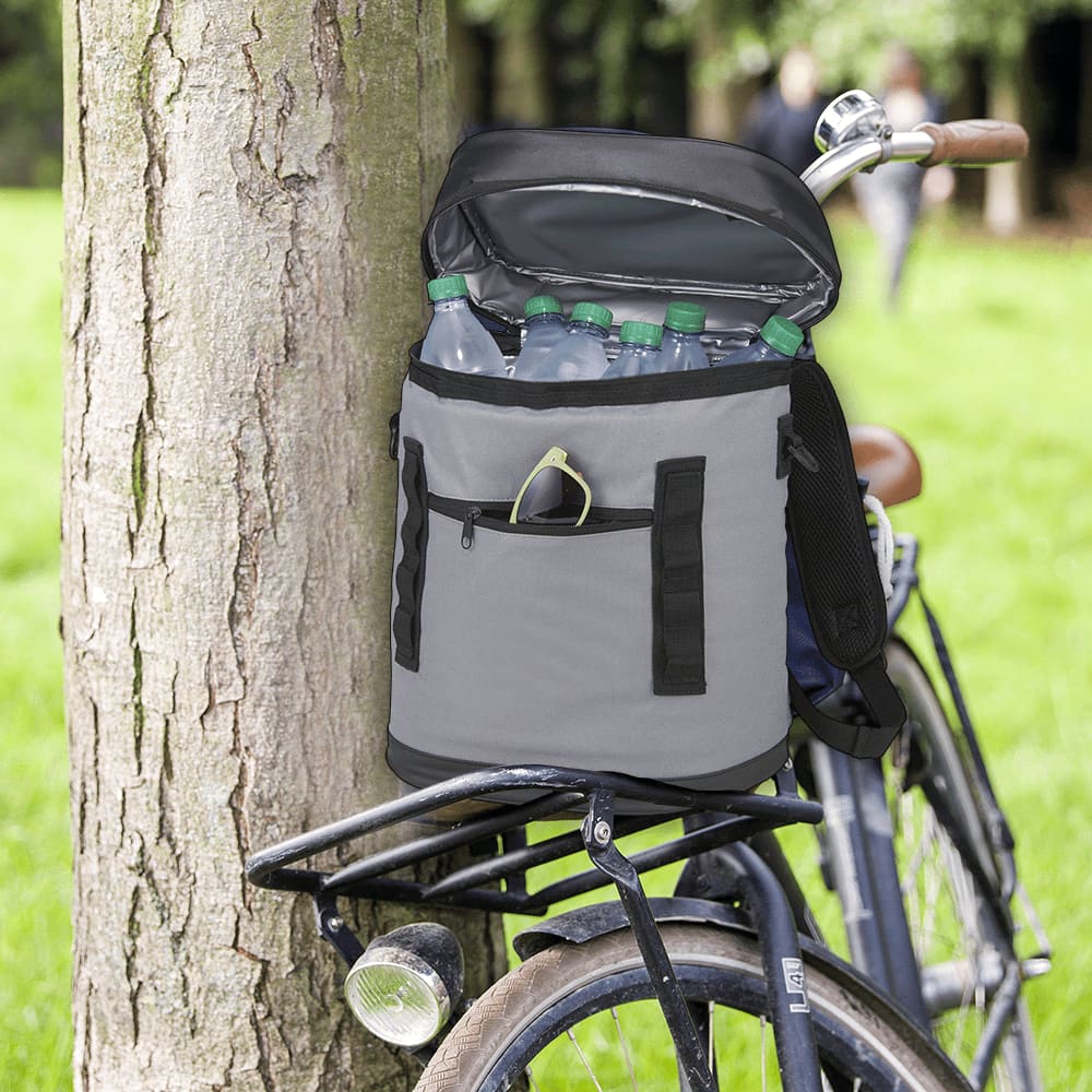 A grey cooler bag with multiple straps, containing food containers, a drink, and utensils inside.