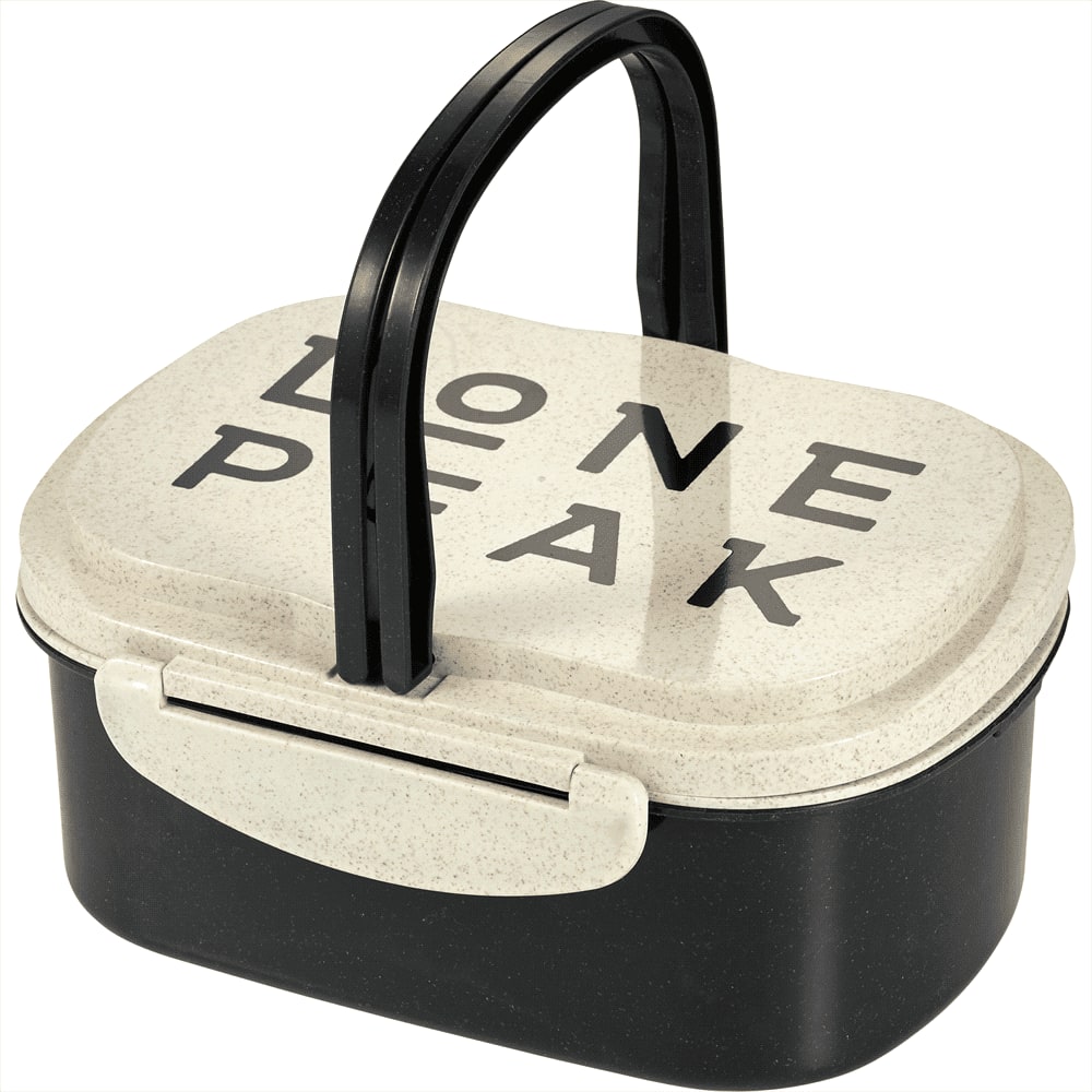 A plastic and wheat straw lunch box in cream and black with a handle and branding on the lid.