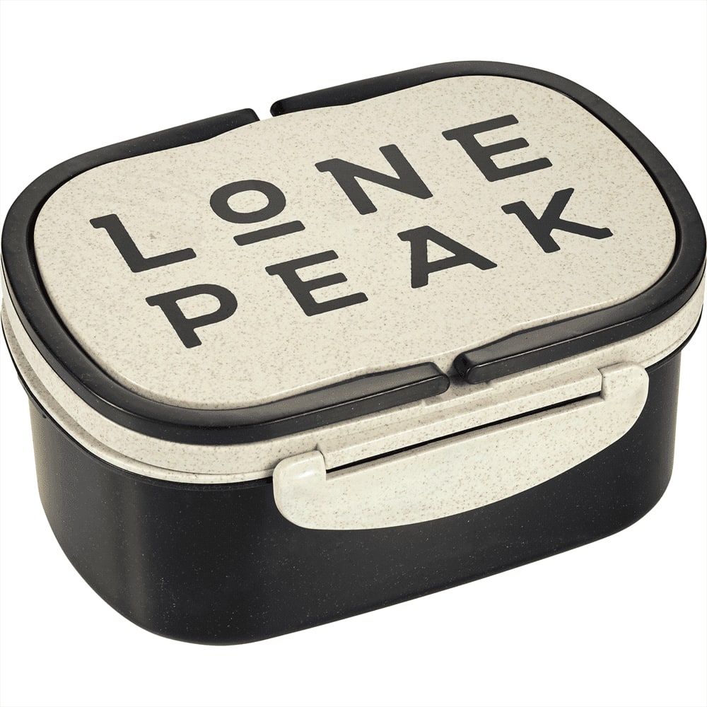 A plastic and wheat straw lunch box in cream and black, featuring a logo on the lid.