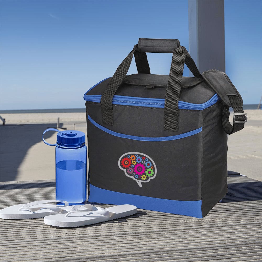 A black and blue cooler bag with a logo, accompanied by a clear drink bottle and white flip-flops on a beachside deck.