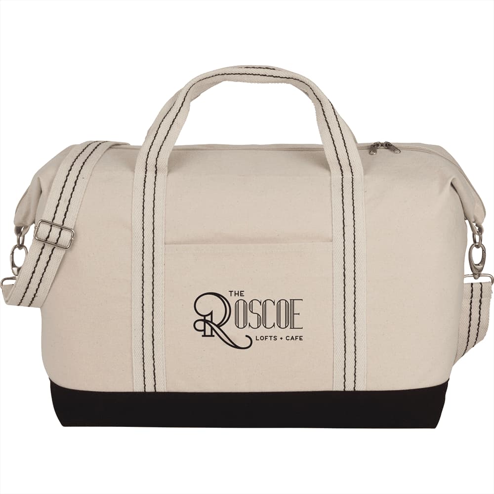 A cotton canvas duffel bag in cream with black accents, featuring handles and a detachable shoulder strap.