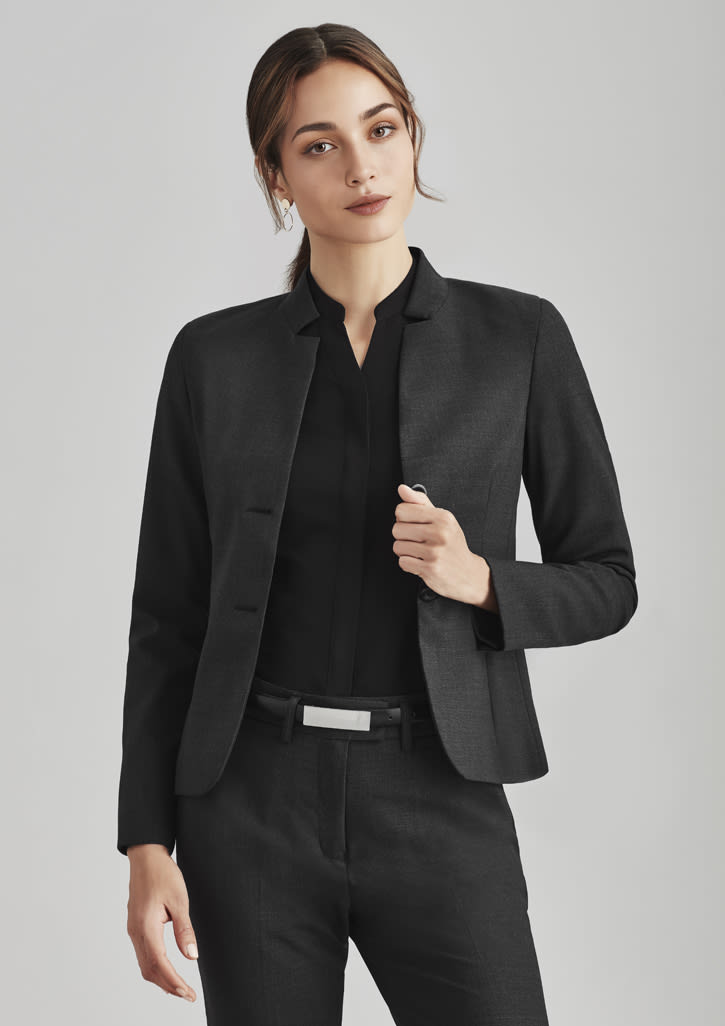 A women's black comfort wool stretch short jacket with reverse lapel, styled with a black top and belted trousers.
