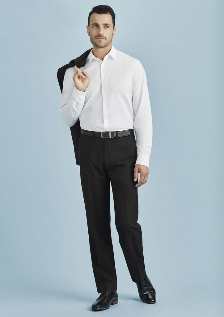 A man wearing a white shirt and black adjustable waist pants, holding a jacket over his shoulder against a light blue background.