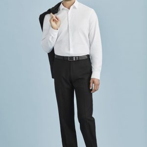 A man in a white shirt and black slacks, holding a jacket over his shoulder against a light blue background.
