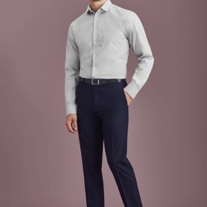 A man wearing a light grey shirt and navy blue slim fit flat front pants, complemented by black shoes and a belt.