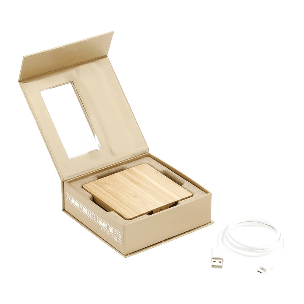 A bamboo wireless charging pad in a packaging box, with a USB cable included. The charger features a natural wood finish.