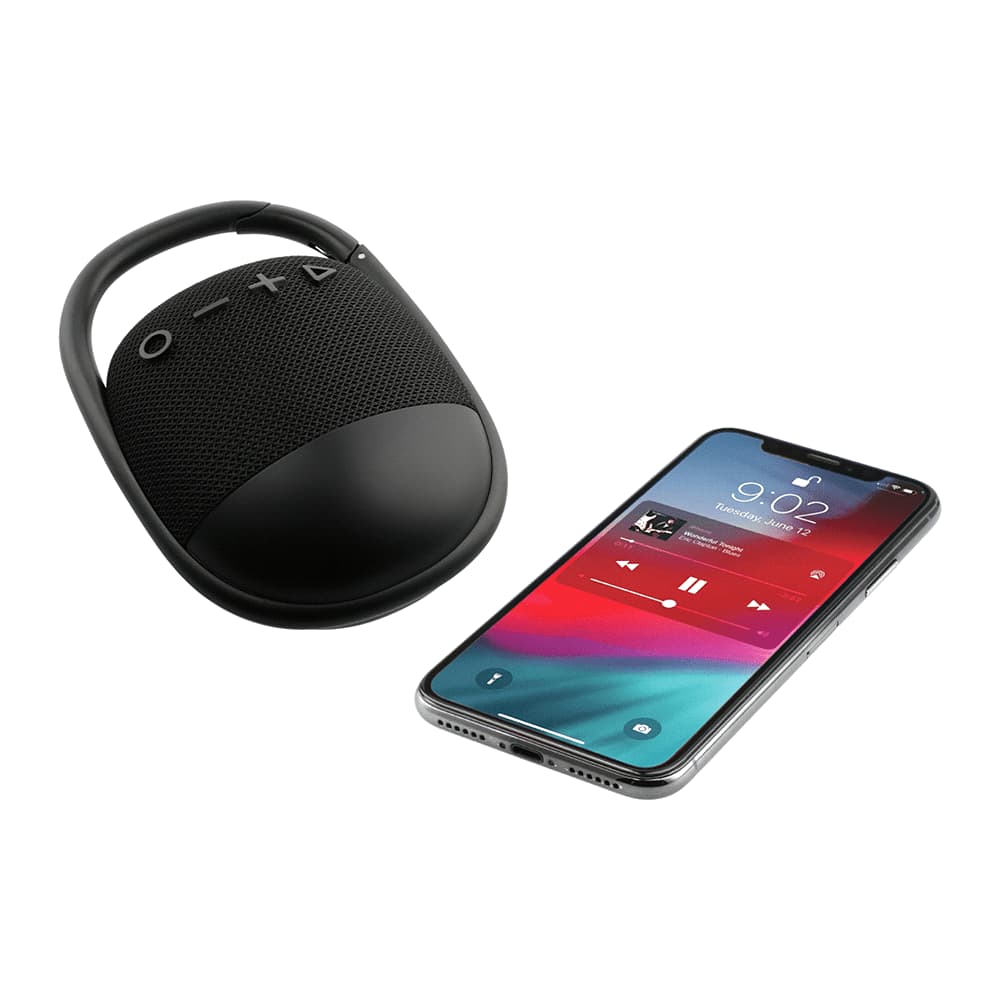 A black waterproof Bluetooth speaker with a handle sits beside a smartphone displaying music playback.