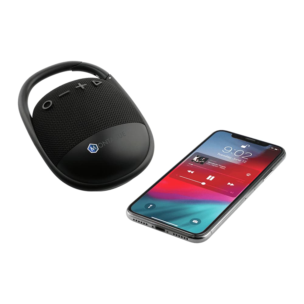 A black waterproof Bluetooth speaker with a handle next to a smartphone displaying a music player interface.