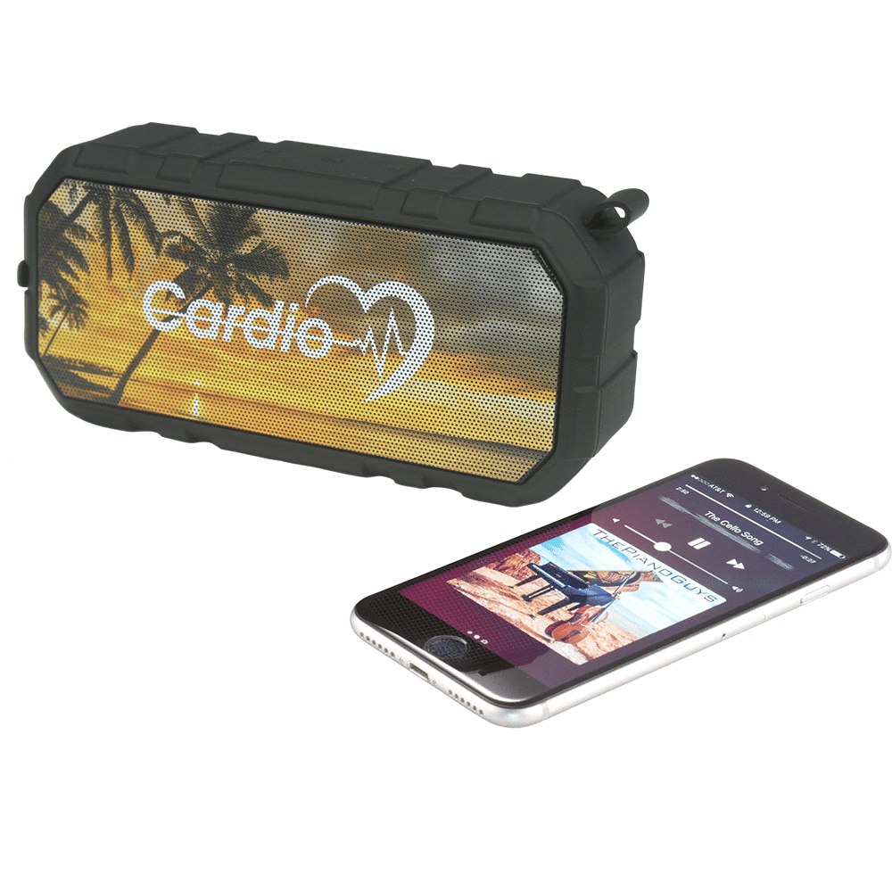 A black, outdoor waterproof Bluetooth speaker beside a smartphone displaying music controls, featuring a tropical background.