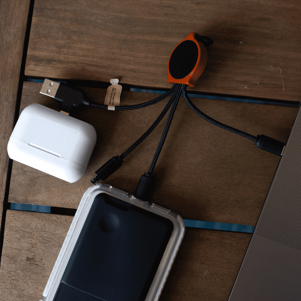 A set of black charging cables made from bamboo and RPET, connected to a white charging case and a phone case.