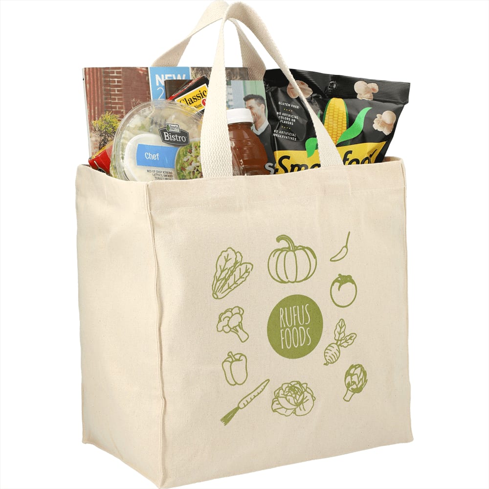 A cream reusable grocery tote containing food items, magazines, and a logo on the front.