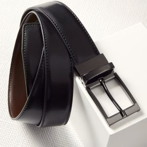 A men's leather reversible belt featuring black on one side and brown on the other, with a metallic buckle and branding.