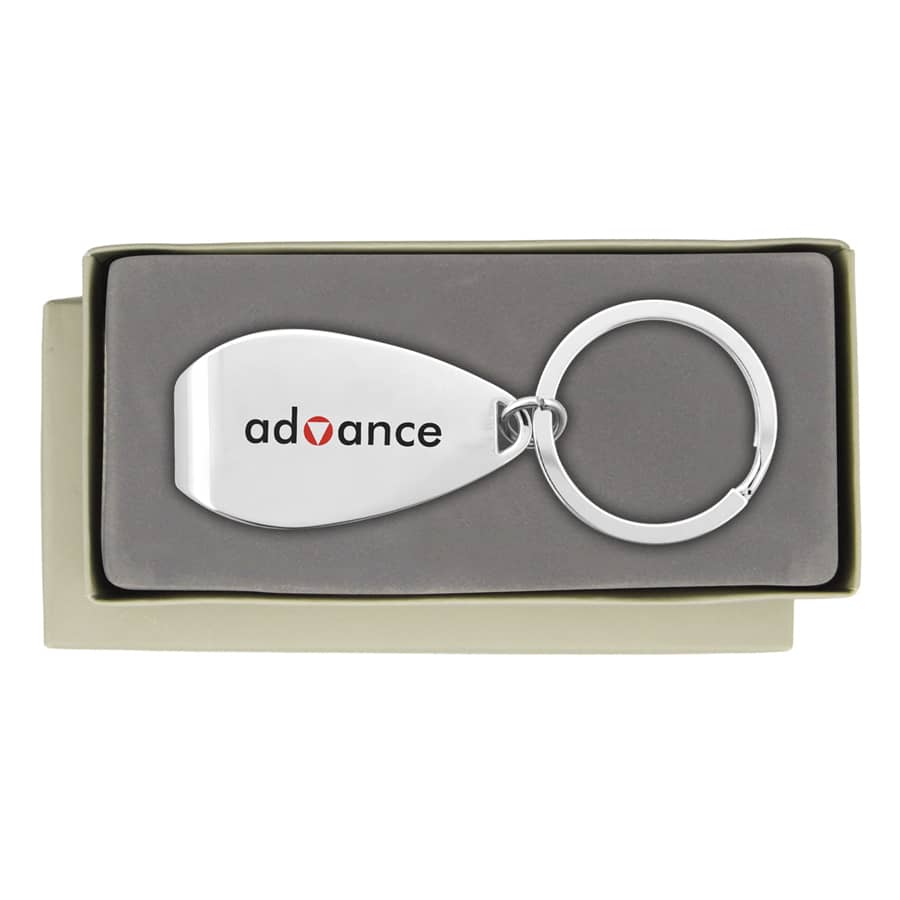 A silver keychain in a grey box, featuring a smooth, metallic surface and a circular ring.