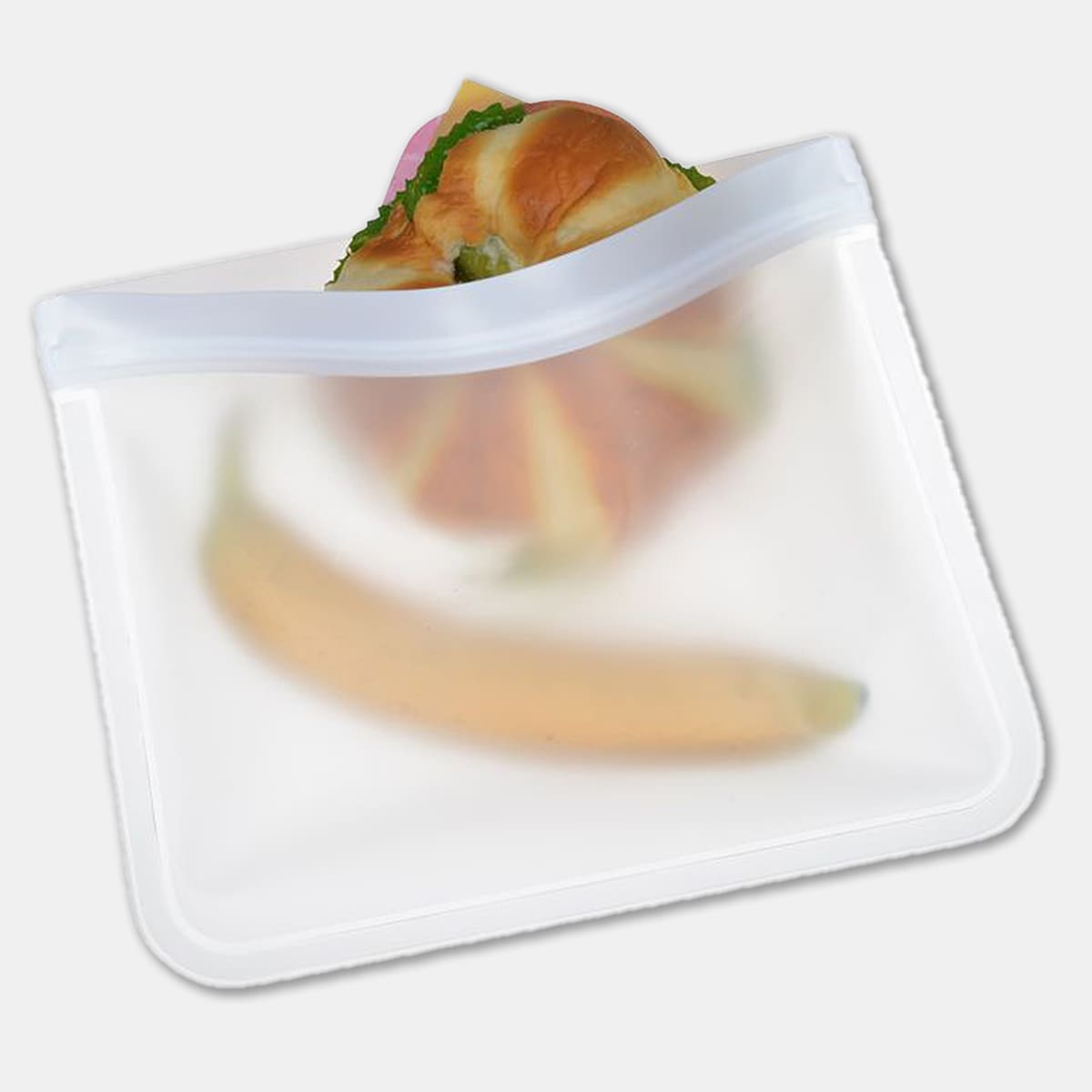 A transparent PEVA reusable food storage bag containing a sandwich and a banana, featuring a zip closure.