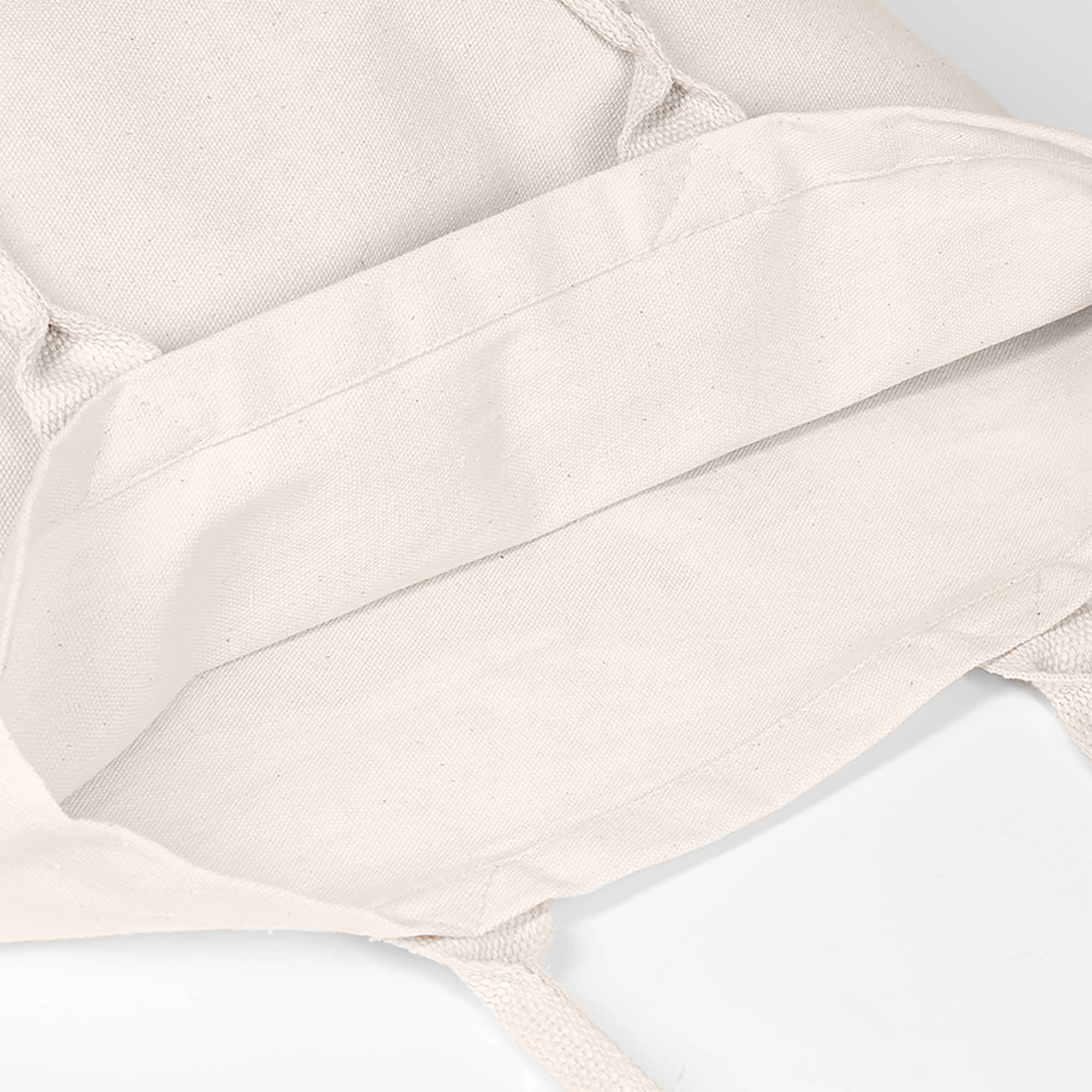 A cream-coloured tote bag with no gusset, featuring shoulder straps and an interior view. It has a logo.