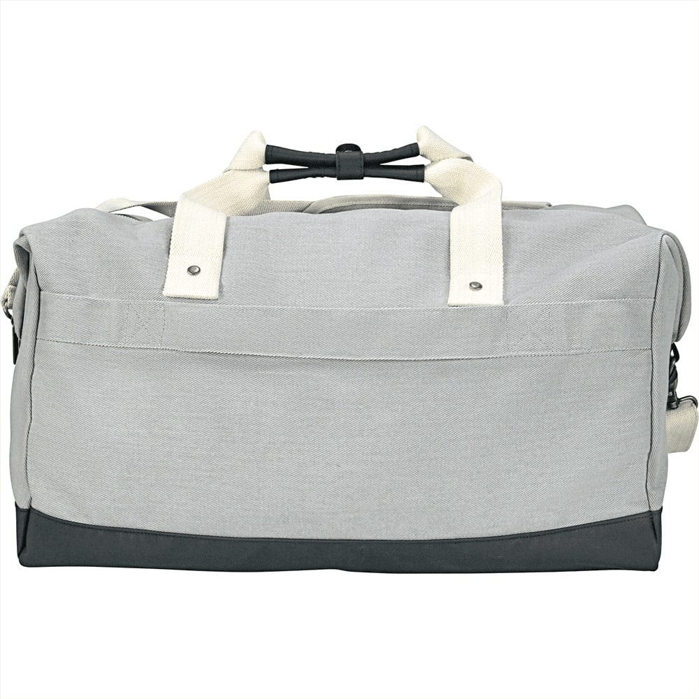 A grey duffel bag with white straps rests on a seating area, featuring a logo on the side.