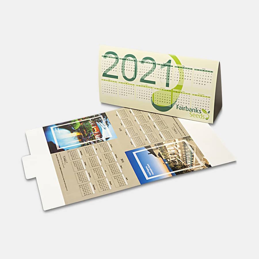 A desk calendar in cream and green featuring a landscape design with monthly views and a logo.