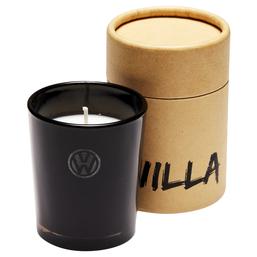 A black glass candle with a white wick, presented in a cylindrical brown cardboard box.