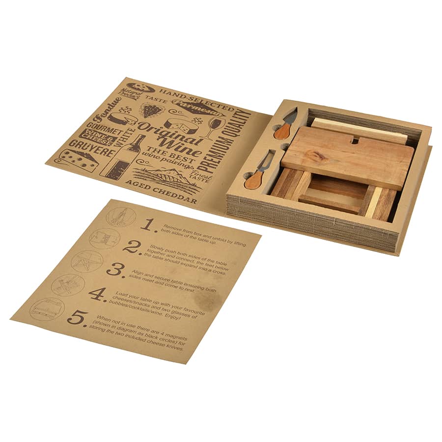 A foldable cheese and wine board in natural wood, featuring utensils and a detailed instruction card.