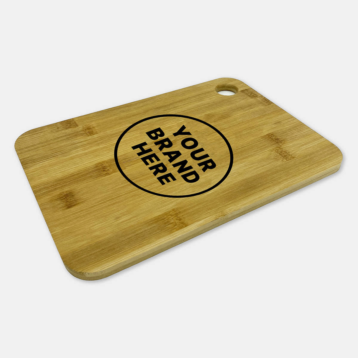 A large bamboo cutting board with a round logo in the centre and a hole for easy hanging.