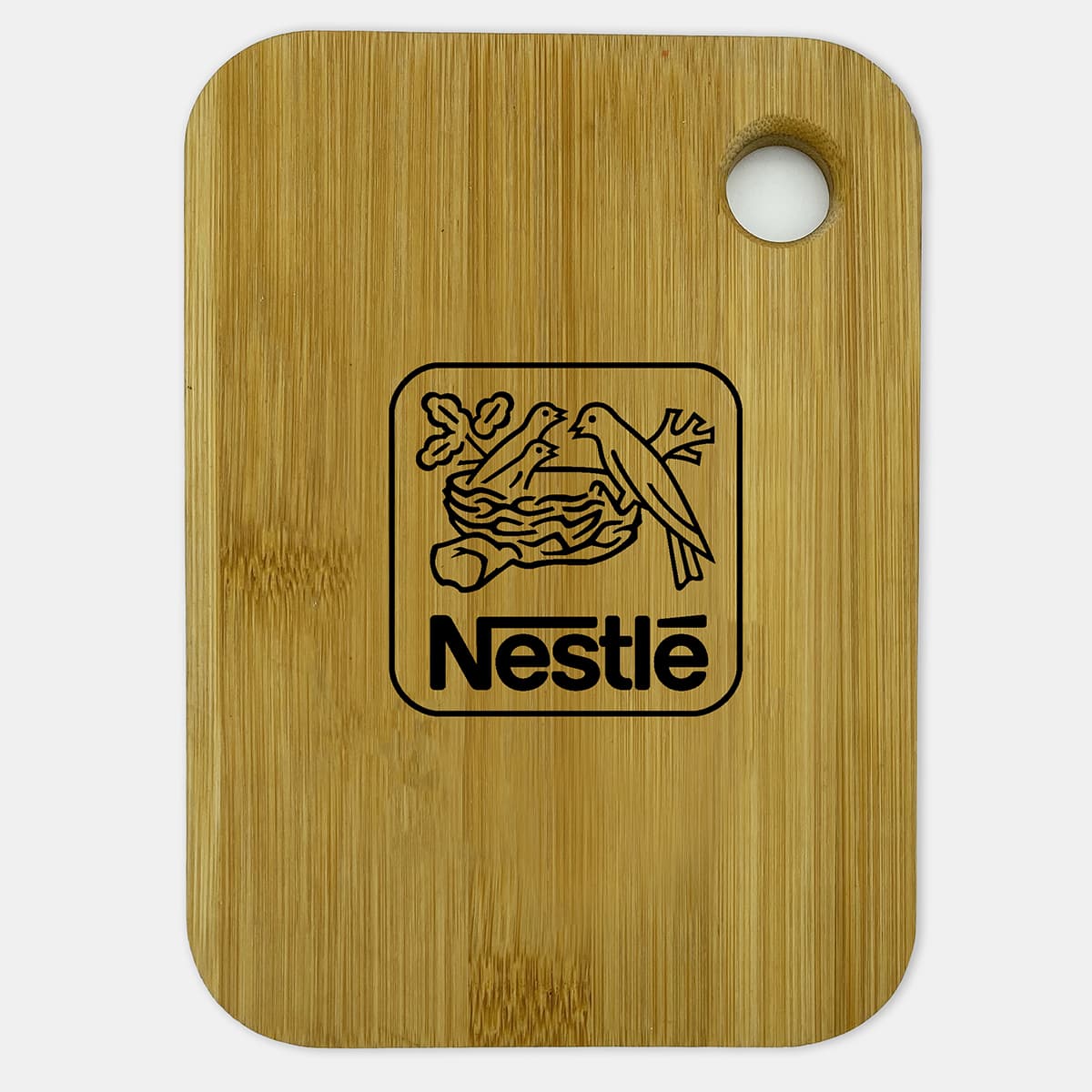 A small bamboo cutting board featuring a circular hole and a logo. The board has a natural wood finish.