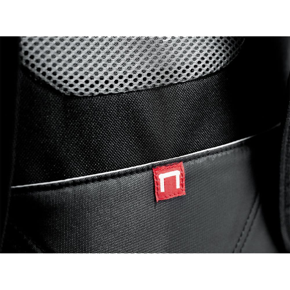 A close-up of a grey backpack featuring multiple zippers and a textured zipper pull. It has a logo on one of the zippers.