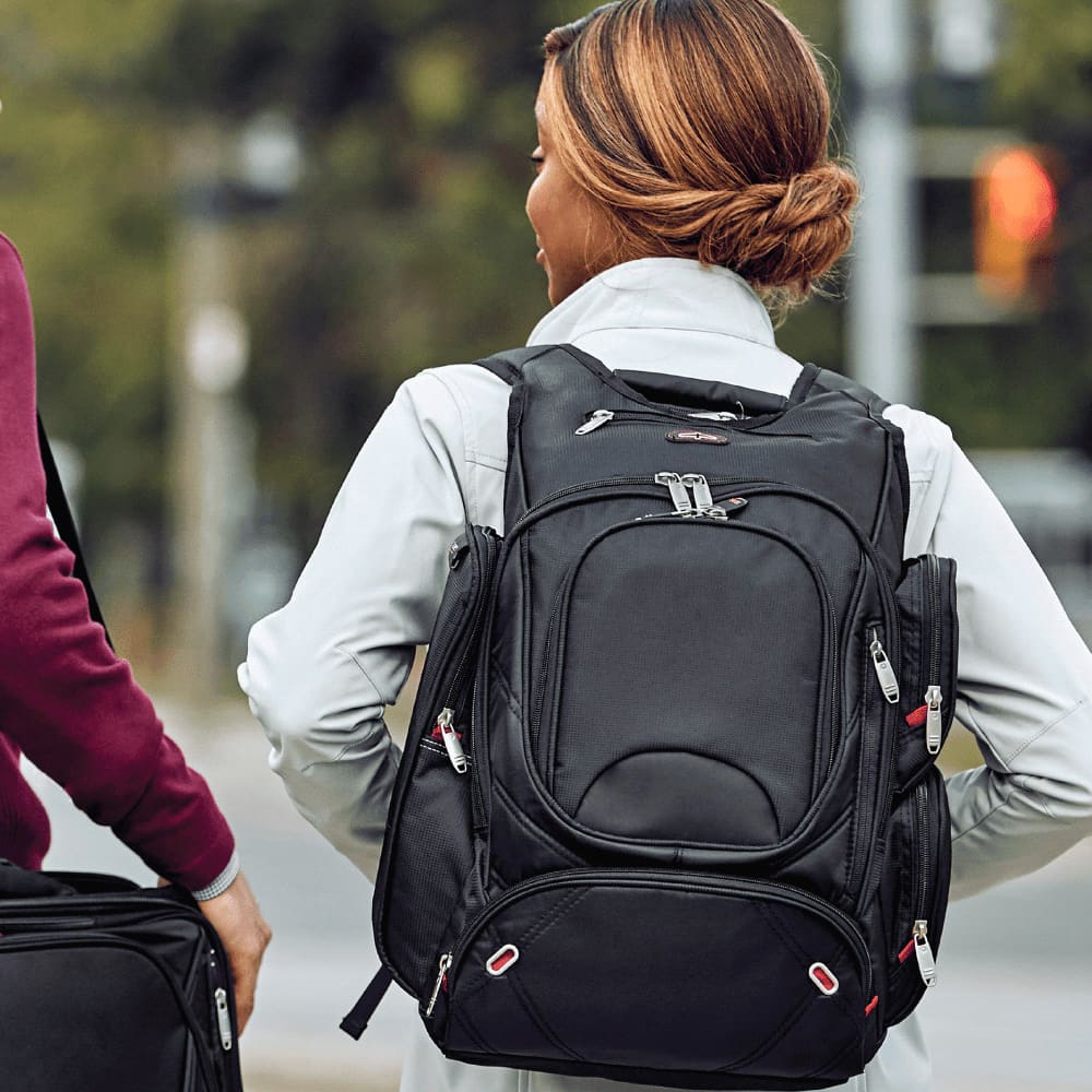 A black backpack with multiple zippered pockets, featuring padded straps and a structured design, ideal for carrying laptops and accessories.