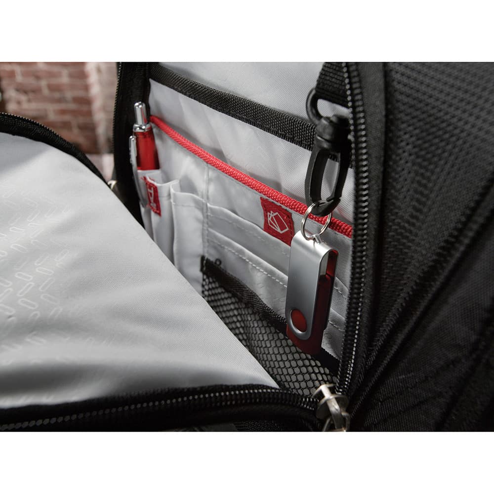 A grey backpack with a smartphone in a pocket, featuring white earphones partially connected.
