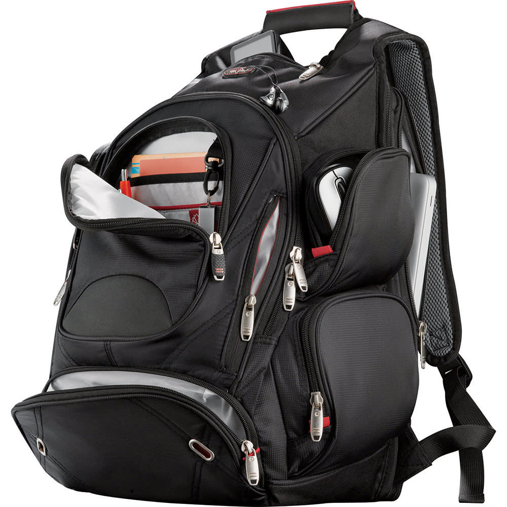 A black backpack with multiple compartments and a logo, carried by a woman outdoors.