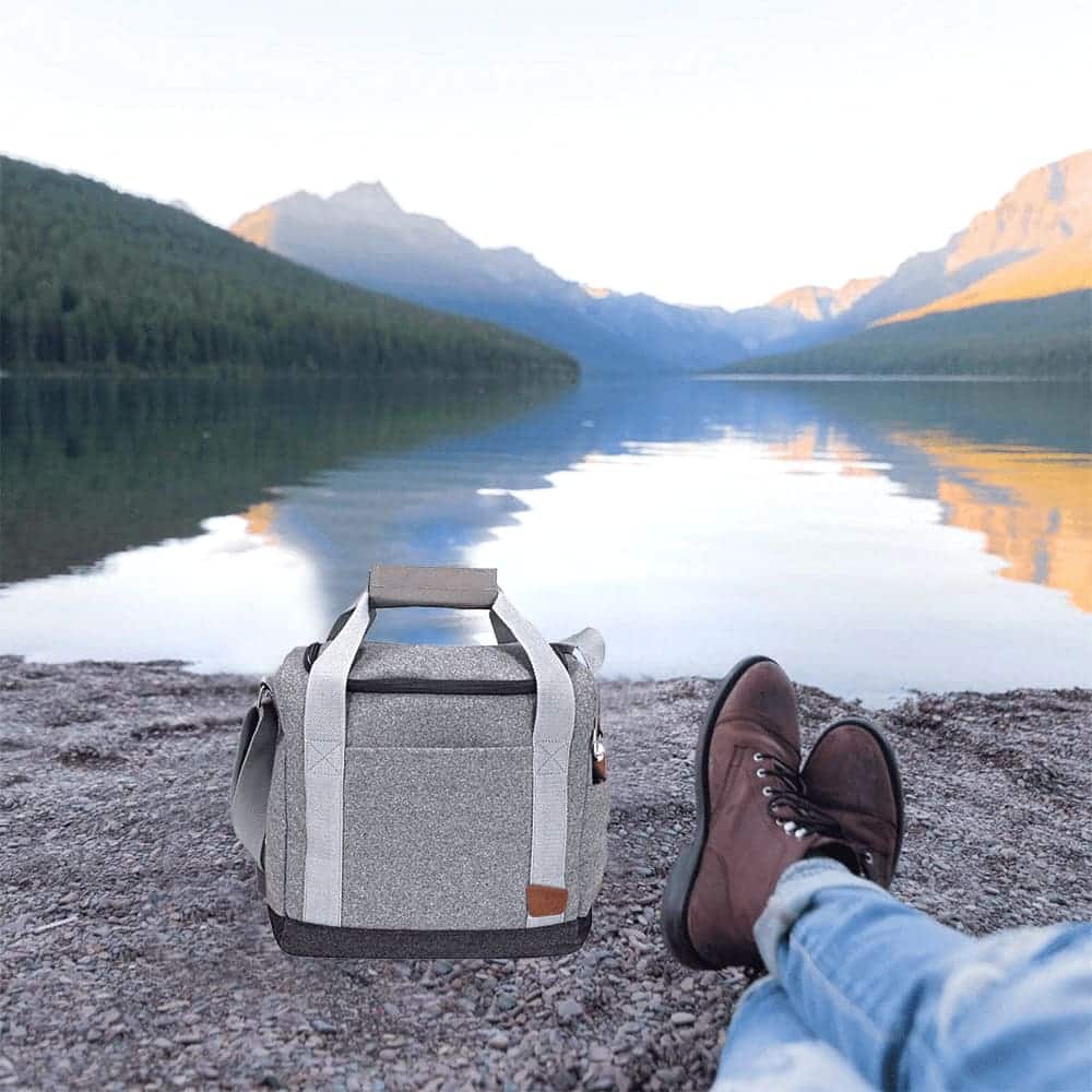 A drink bottle cooler bag in grey with brown accents, featuring an open top and bottle opener attached.
