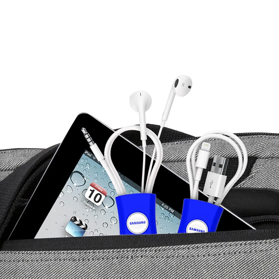 A blue cable manager holds earbuds and charging cables, placed inside a bag with a tablet visible.