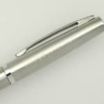 A sleek silver pen with a clip, featuring a polished surface and minimalistic design.