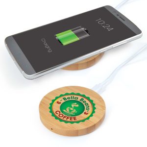 A round bamboo wireless charger with a smartphone displaying a charging battery icon and a logo on the charger.