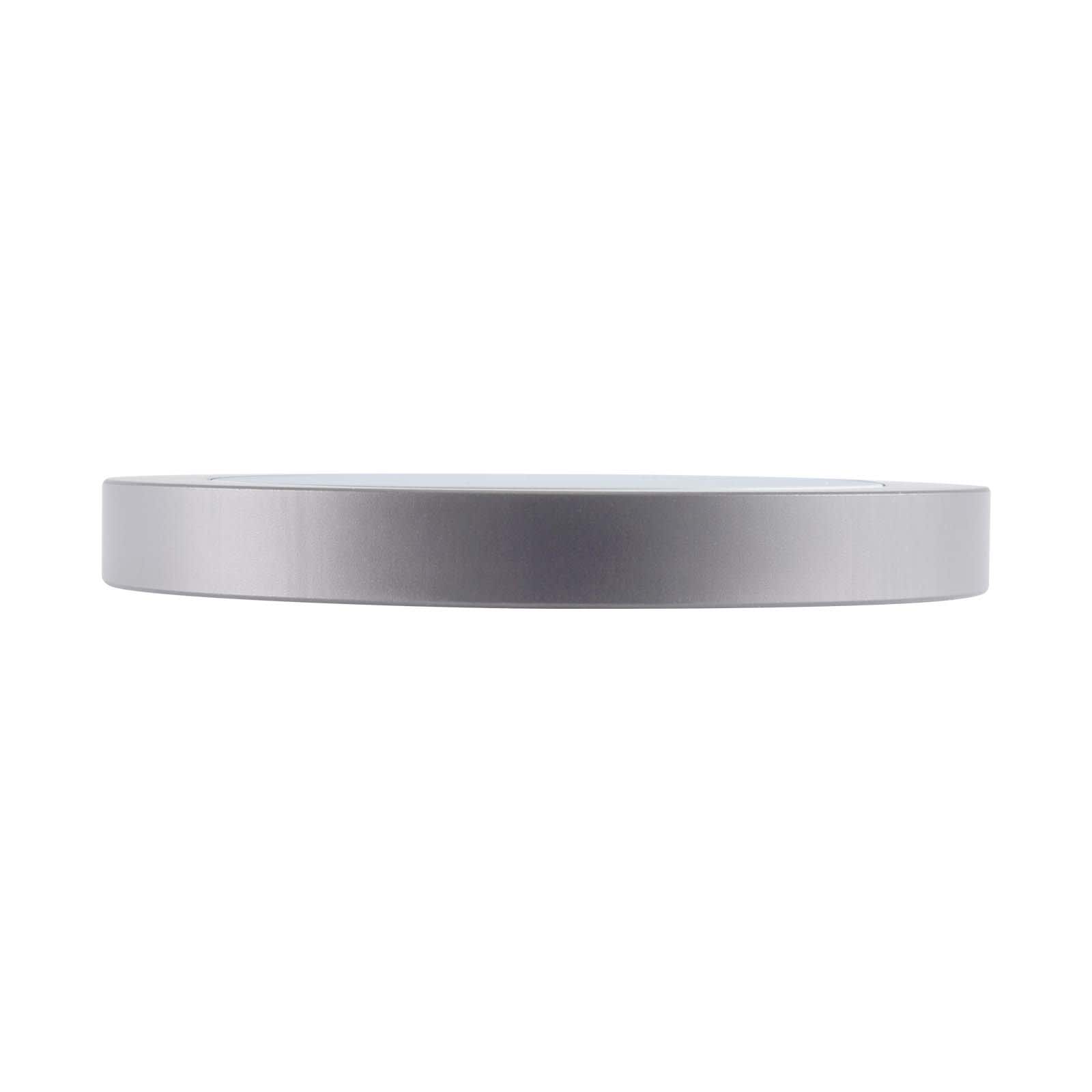 A sleek silver wireless charger with a minimalist design and a round shape. It features a logo on the surface.