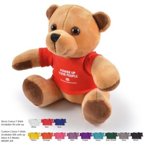 A fluffy tan teddy bear wearing a red T-shirt, sitting upright against a white background. Includes branding on the shirt.
