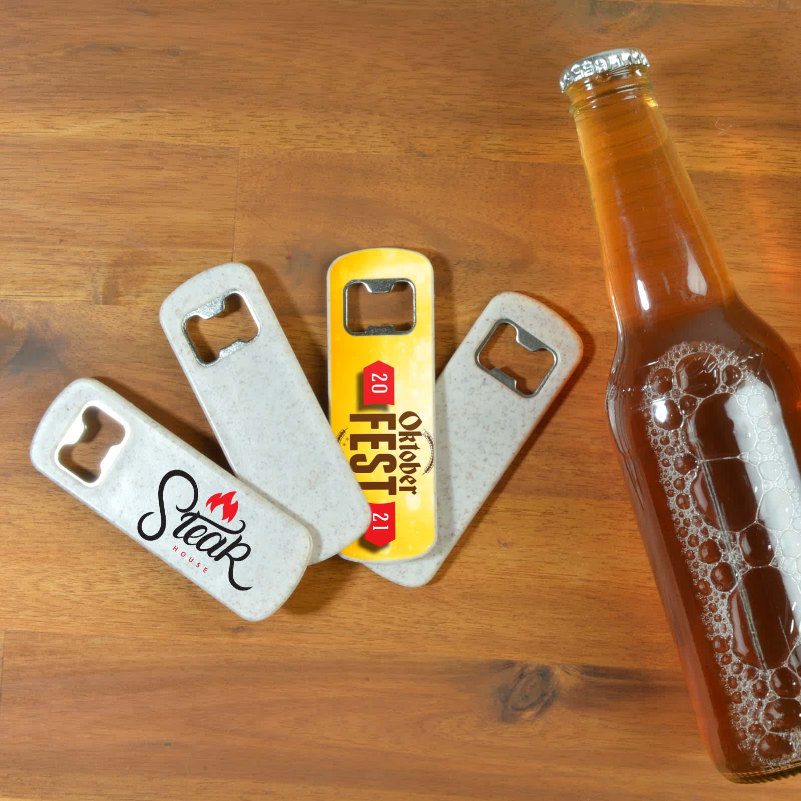 A drink bottle alongside three Arctic Bottle Openers, featuring different designs and logos.