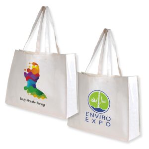A woman holds a large white reusable grocery bag with two long handles. It appears spacious and made of bamboo fabric.