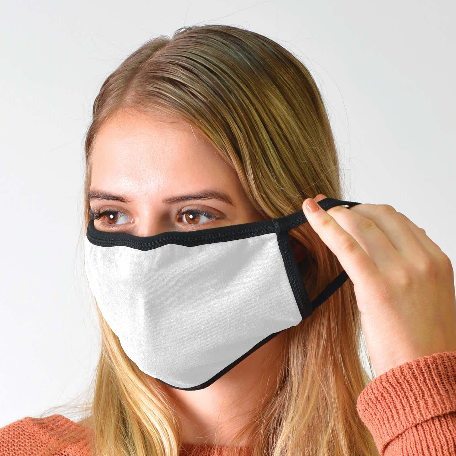 A woman wearing a white cotton face mask with black trim. The mask is fitted over her nose and mouth.