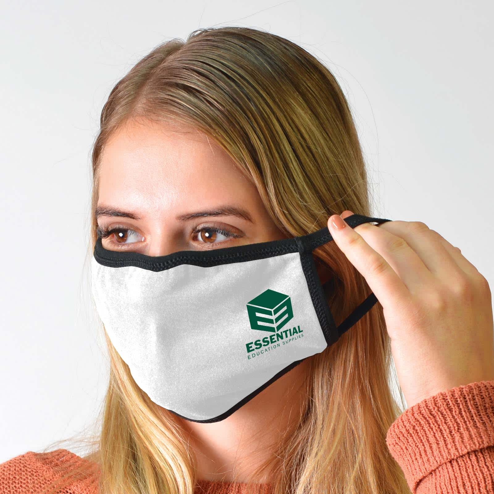 A face mask in white with a black trim, worn by a person, featuring a logo on the front.