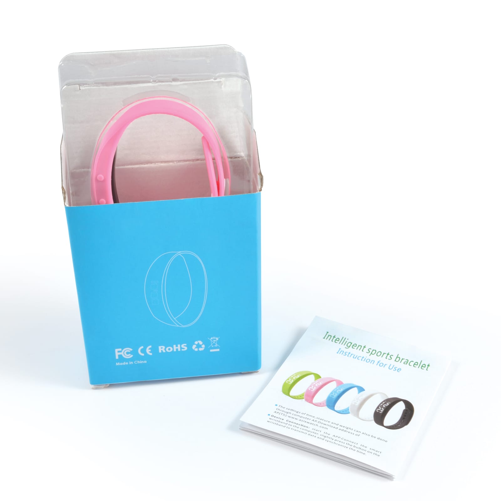 A pink pedometer bracelet in a box, with a user instruction booklet beside it.